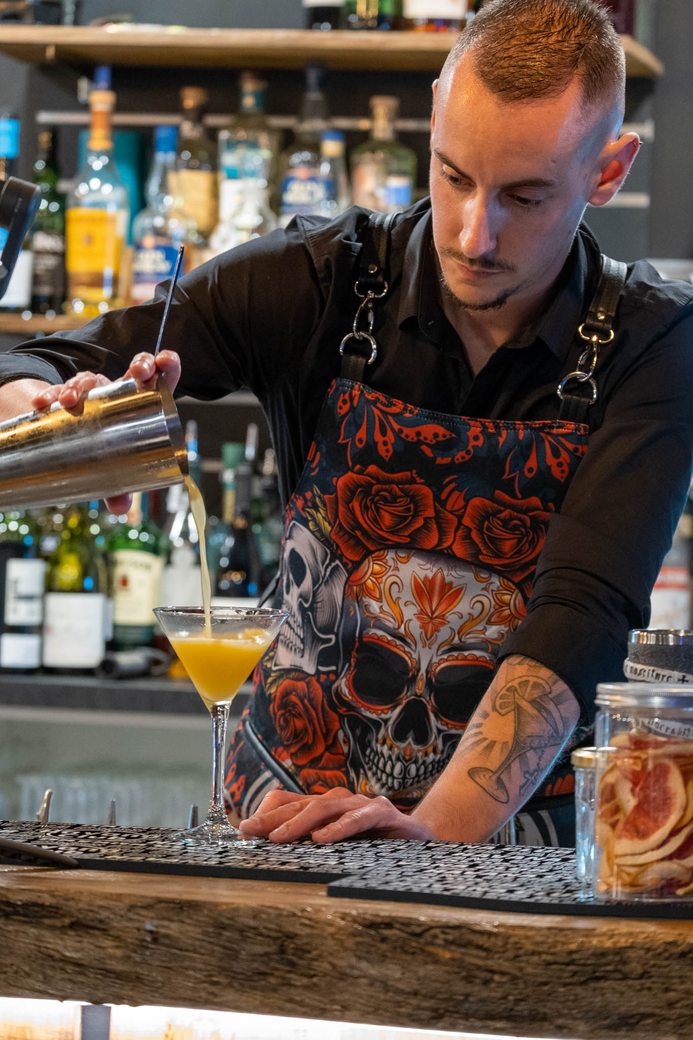 barman professionnel préparant un cocktail dans un bar