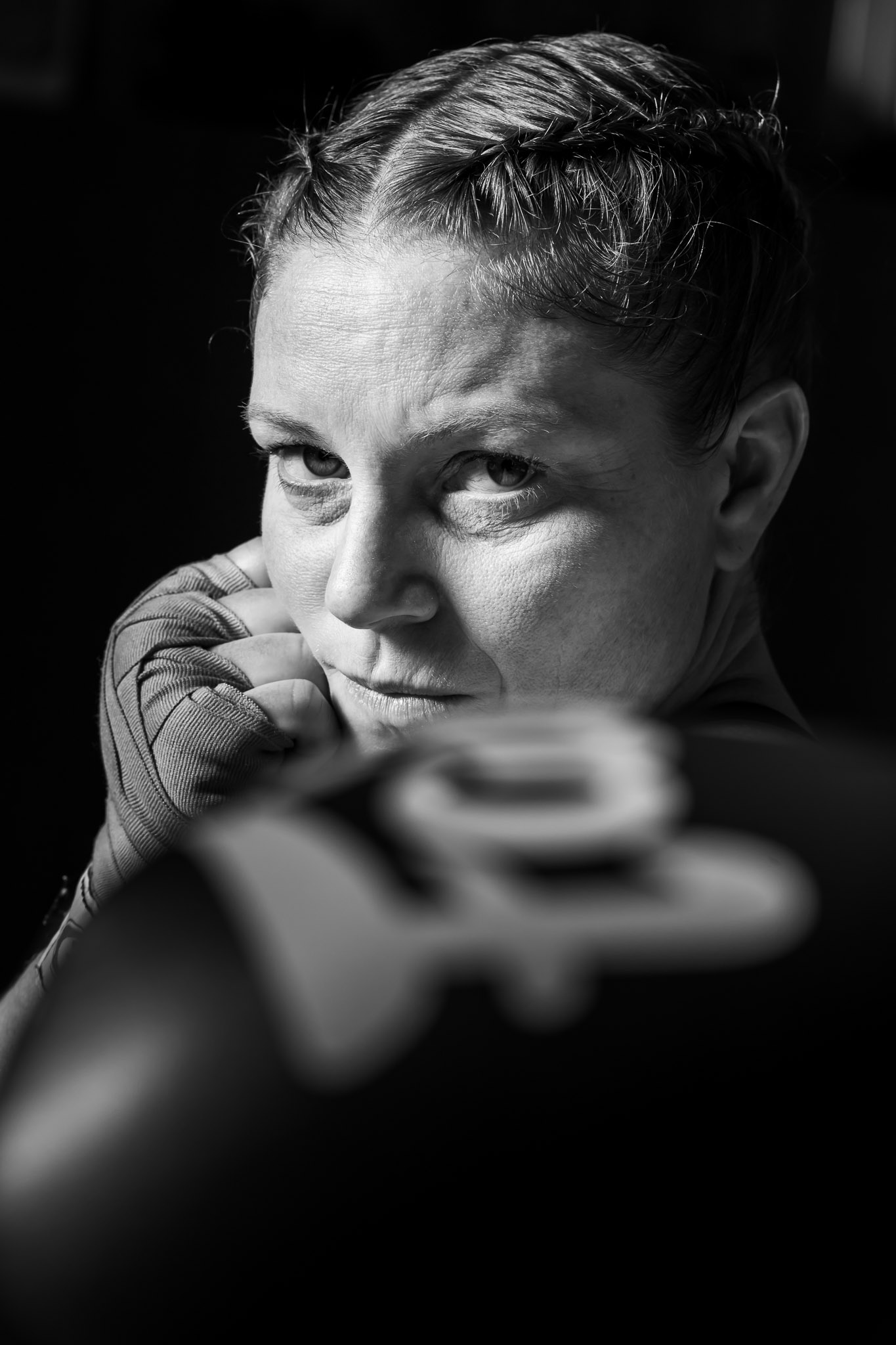 Portrait noir et blanc d’Anne avec gant de boxe et regard concentré